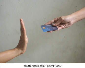one hand holding a credit card, the other hand with an open palm facing the credit card
