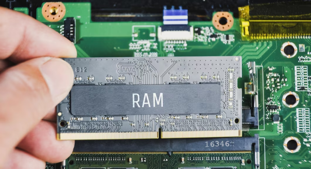 Hand Holding Computer RAM Above Circuit Board